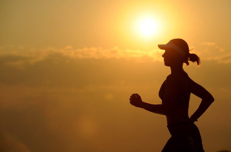 woman with white sunvisor running