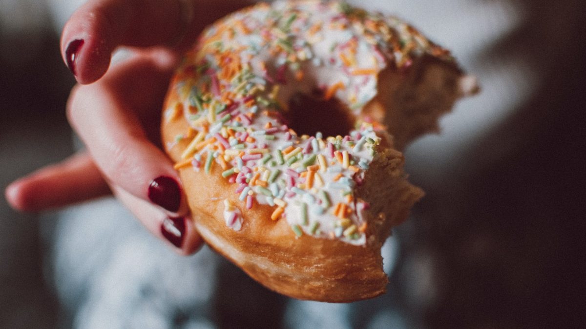 selective focus photograph of half eaten doughnut with sprinkles