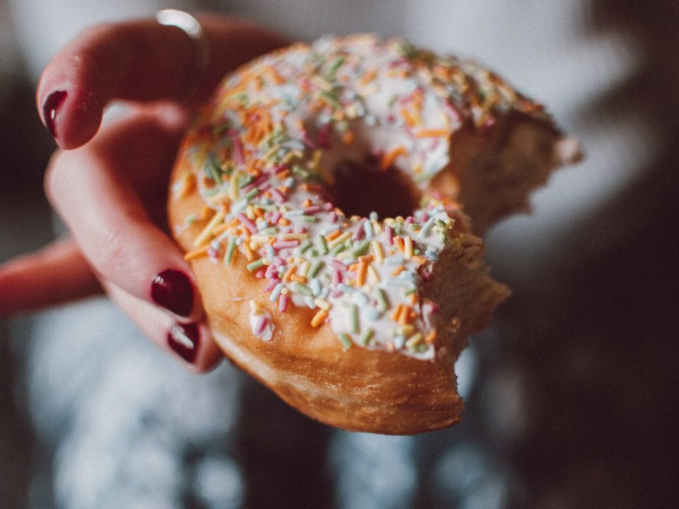 selective focus photograph of half eaten doughnut with sprinkles