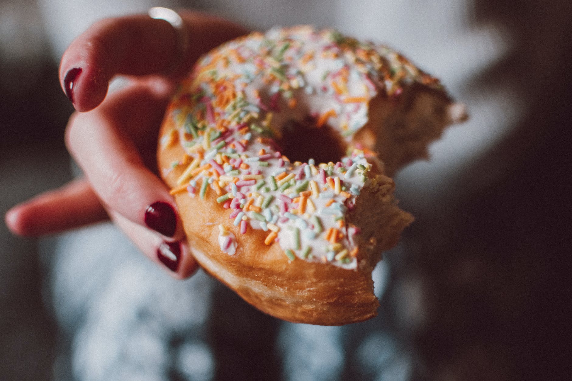 selective focus photograph of half eaten doughnut with sprinkles